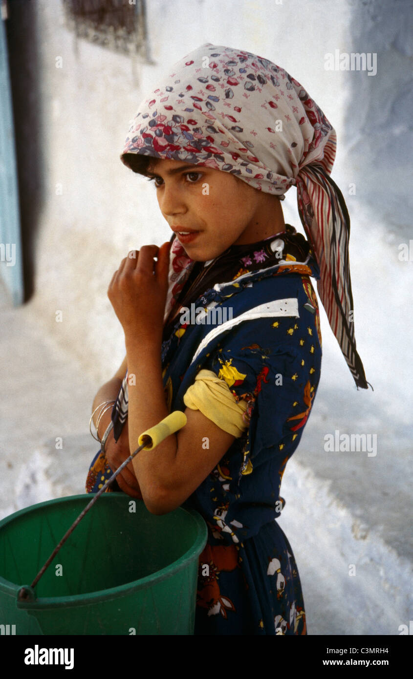 Chechaouen Maroc Enfant avec godet sur sa façon de se laver dans la rivière Banque D'Images