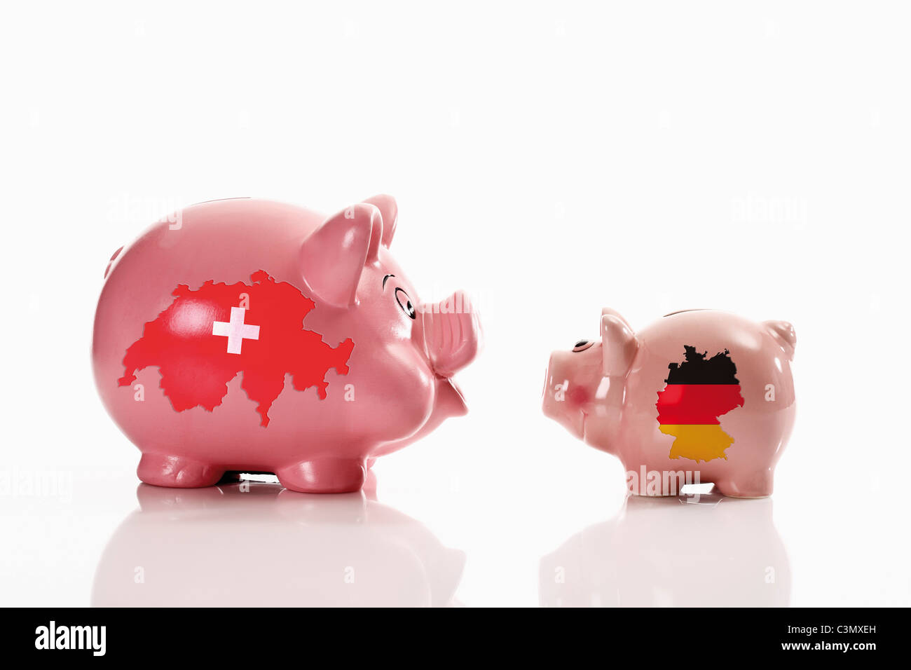 Tirelire avec drapeaux suisses et allemands sur fond blanc Banque D'Images