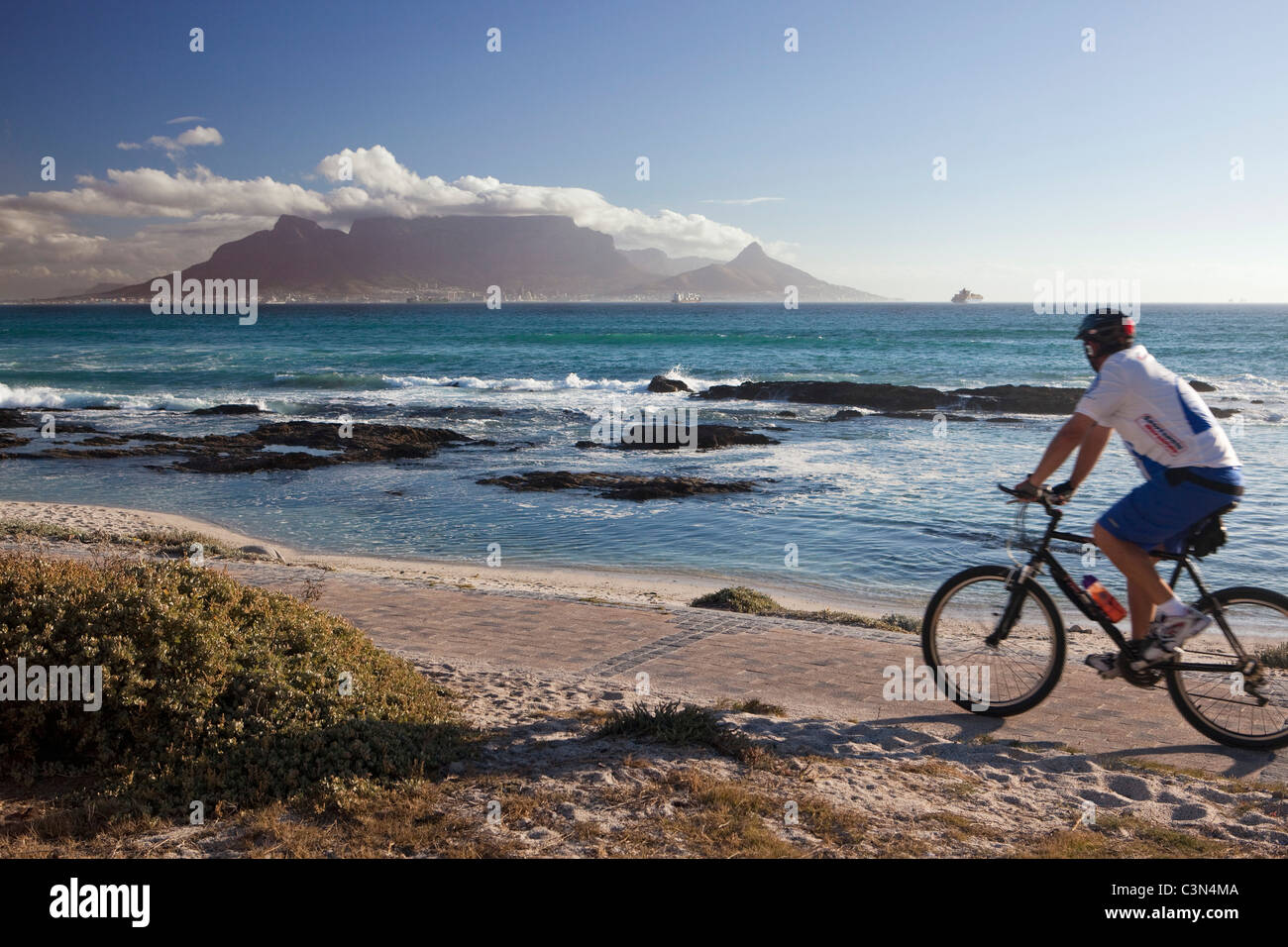 L'Afrique du Sud, Cape Town, Blouberg beach. Cycliste. Contexte : la montagne de la table. Banque D'Images