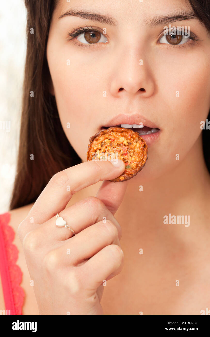 Jeune femme mangeant un biscuit Banque D'Images