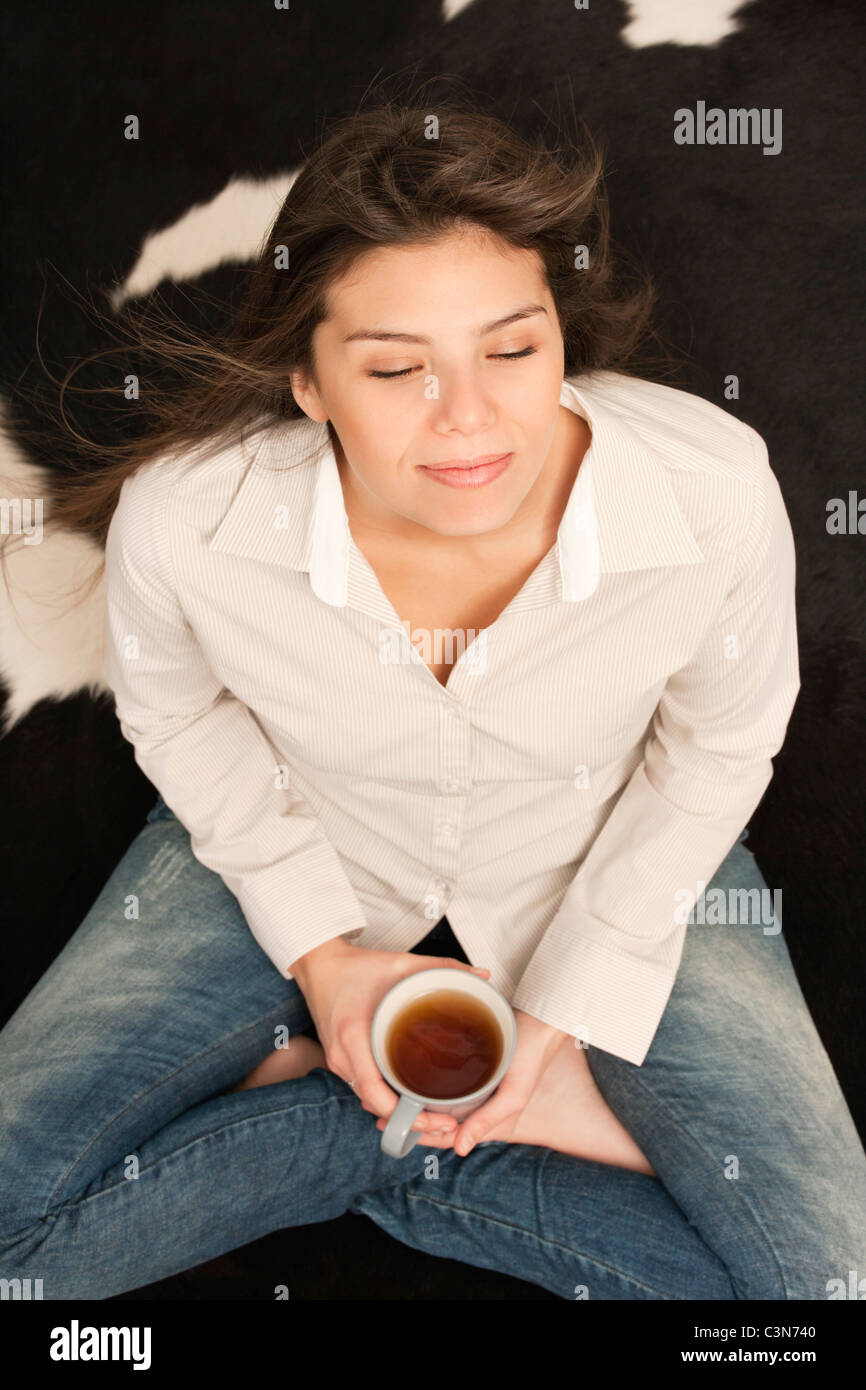 Femme ayant une tasse de thé, assis Banque D'Images