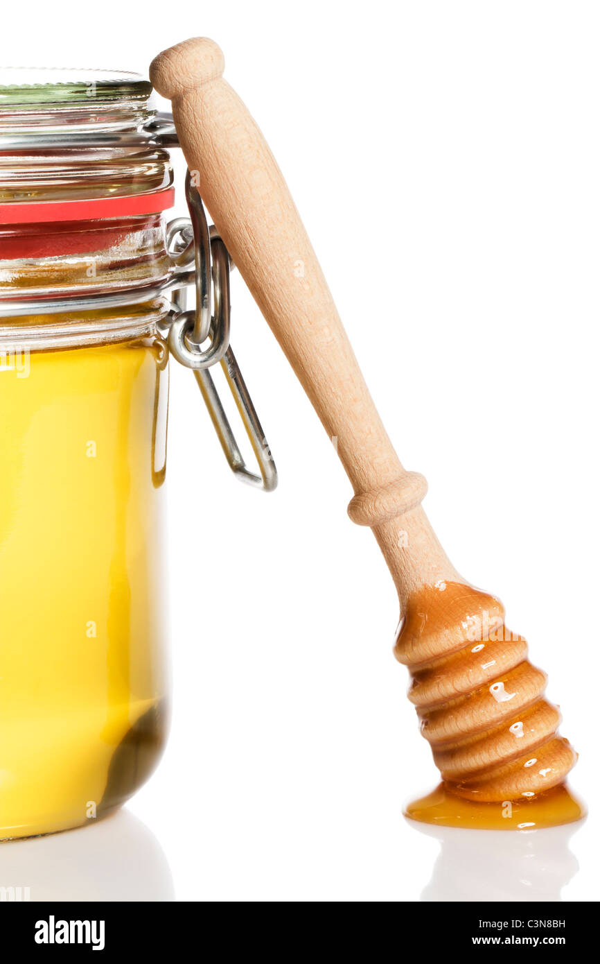 Couvert de miel miel Le miel à un penchant de balancier sur fond blanc Banque D'Images