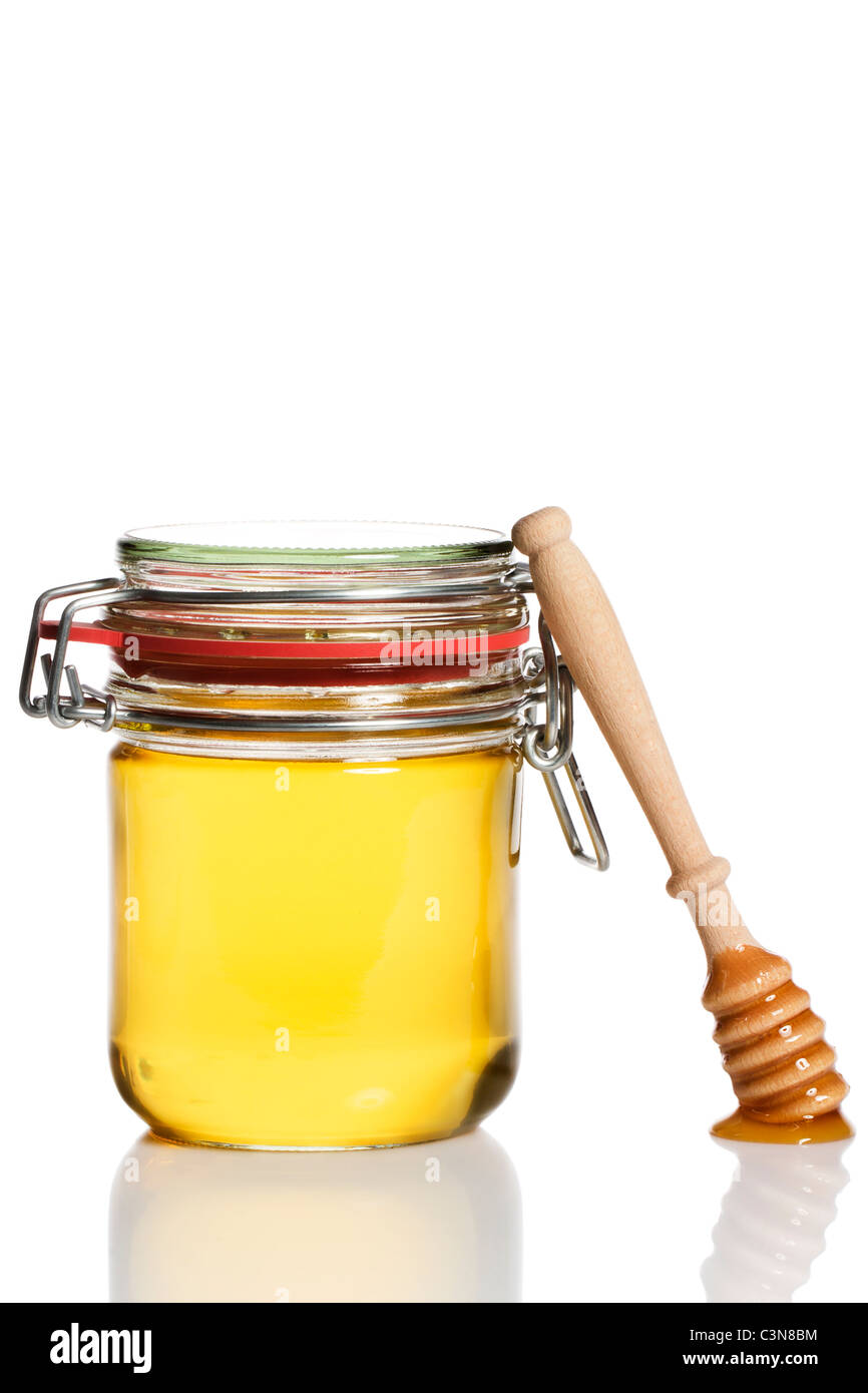 Couvert de miel miel Le miel à un penchant de balancier sur fond blanc Banque D'Images