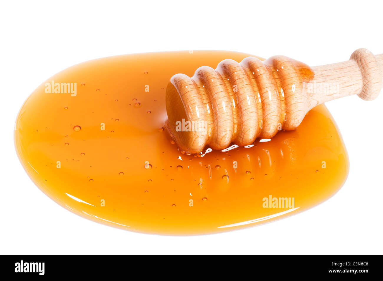 Balancier de miel un peu haut dans une flaque de miel sur fond blanc Banque D'Images