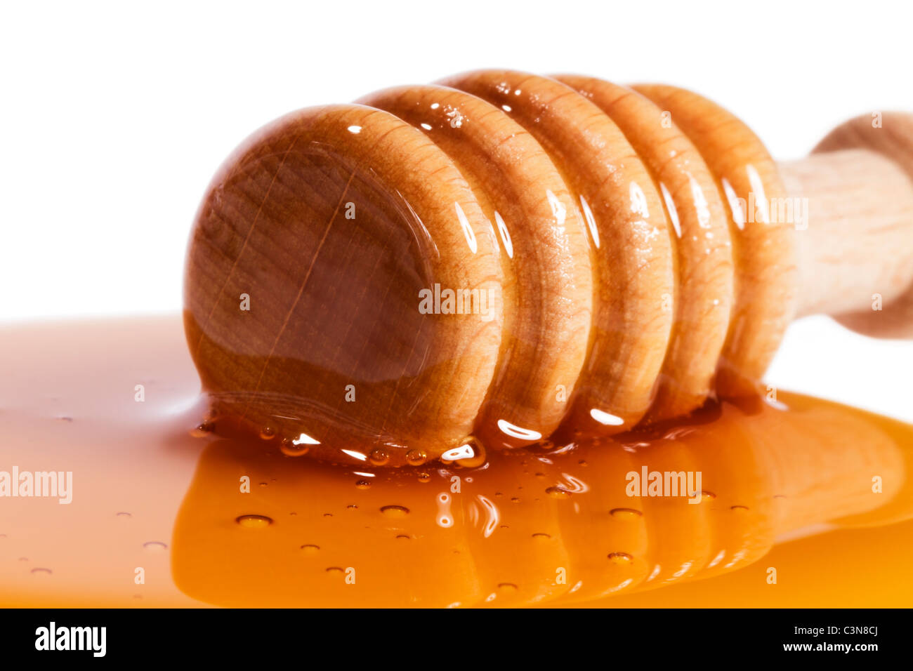 Libre d'un balancier de miel dans une flaque de miel Banque D'Images