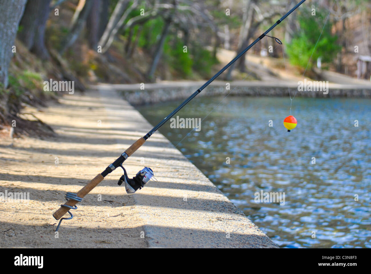 Canne à pêche avec un flotteur près du lac. Banque D'Images