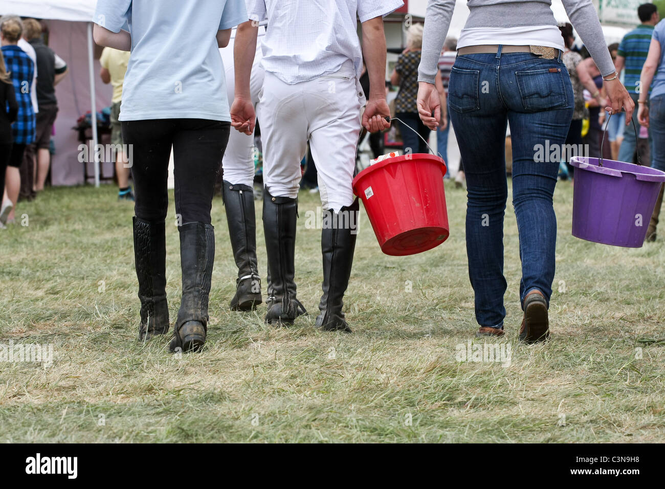 Les jeunes jockeys femelle transportant des seaux au South Suffolk Show tenu à Ampton, Suffolk, le 8 mai 2011 Banque D'Images