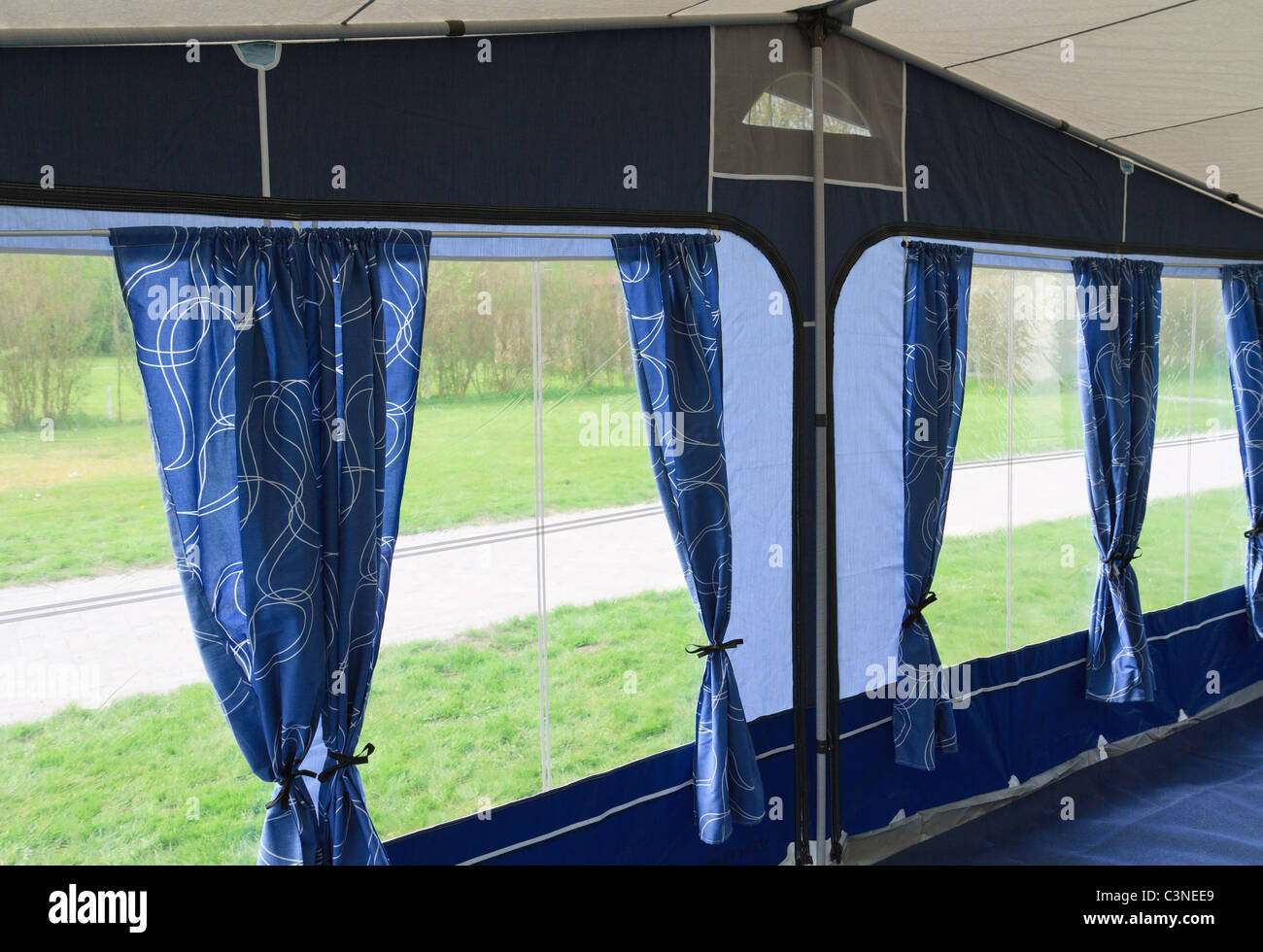 À l'intérieur de l'auvent caravane tente avec des rideaux bleus et quatre fenêtres Banque D'Images