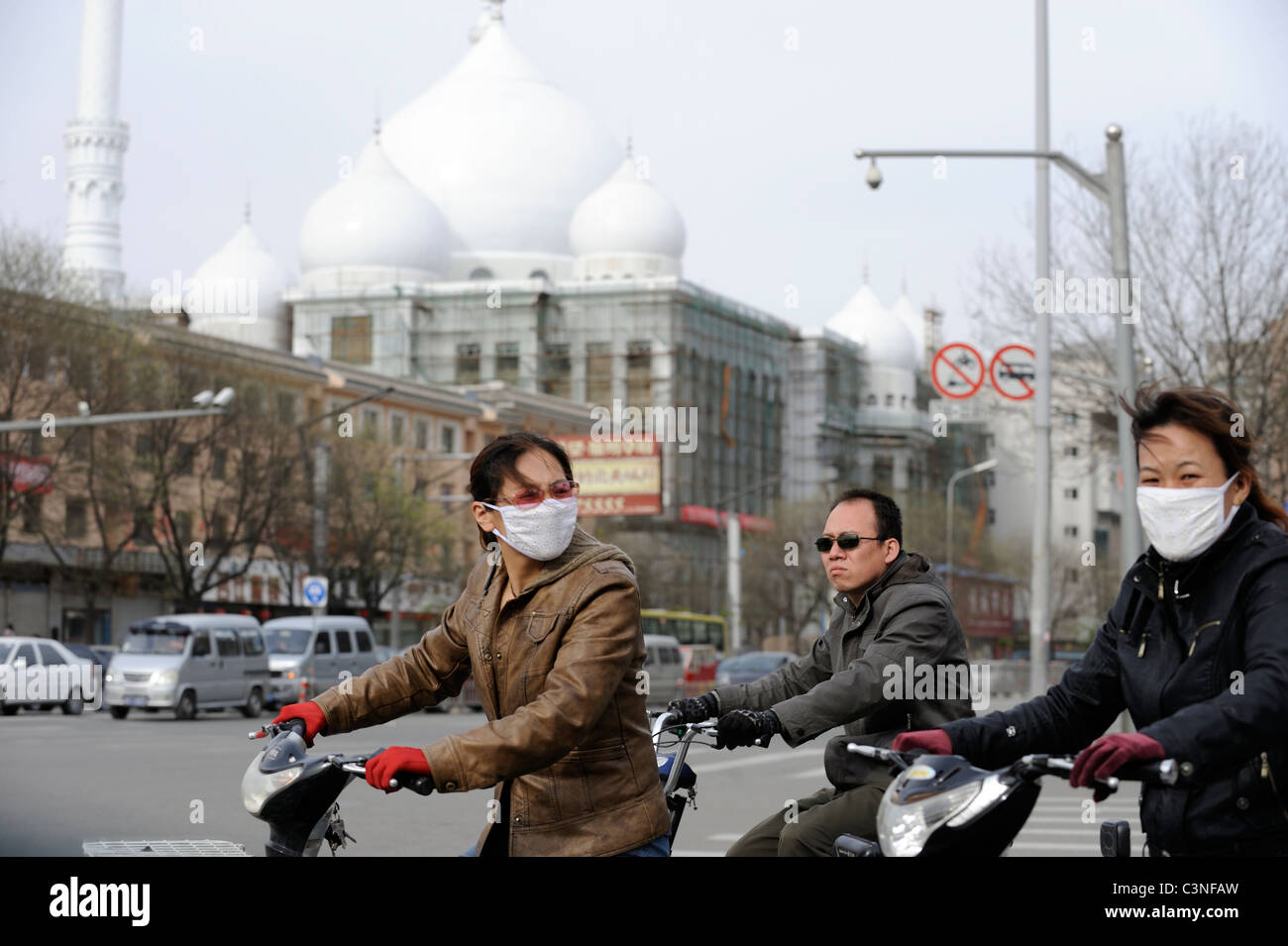 Deux femmes portent des masques alors que la bicyclette à Hohhot, capitale de la Mongolie intérieure, en Chine.11-mai-2011 Banque D'Images