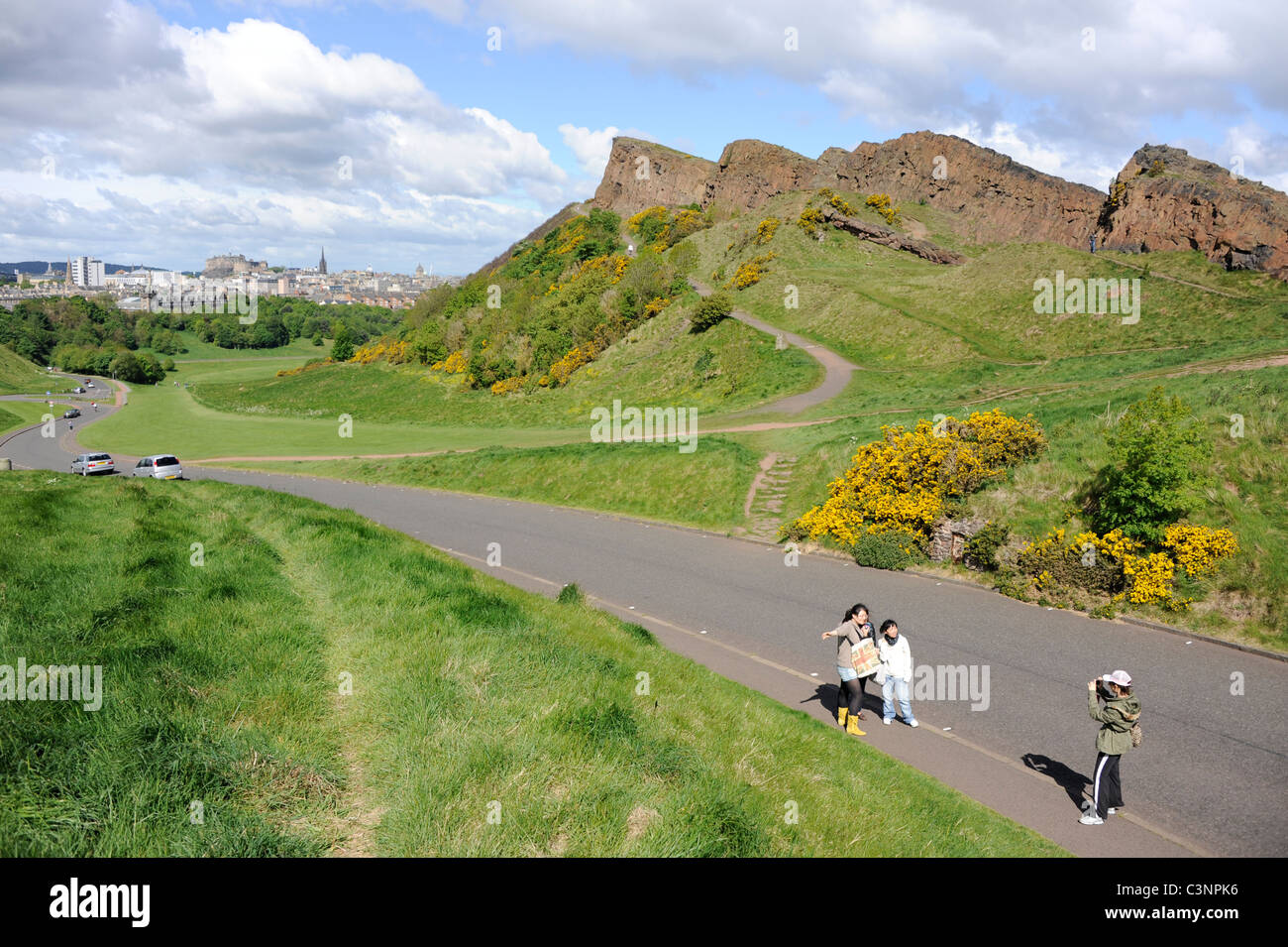Les touristes prendre une photo à côté de Salisbury Crags de Holyrood Park dans le centre d'Édimbourg, en Écosse. Banque D'Images
