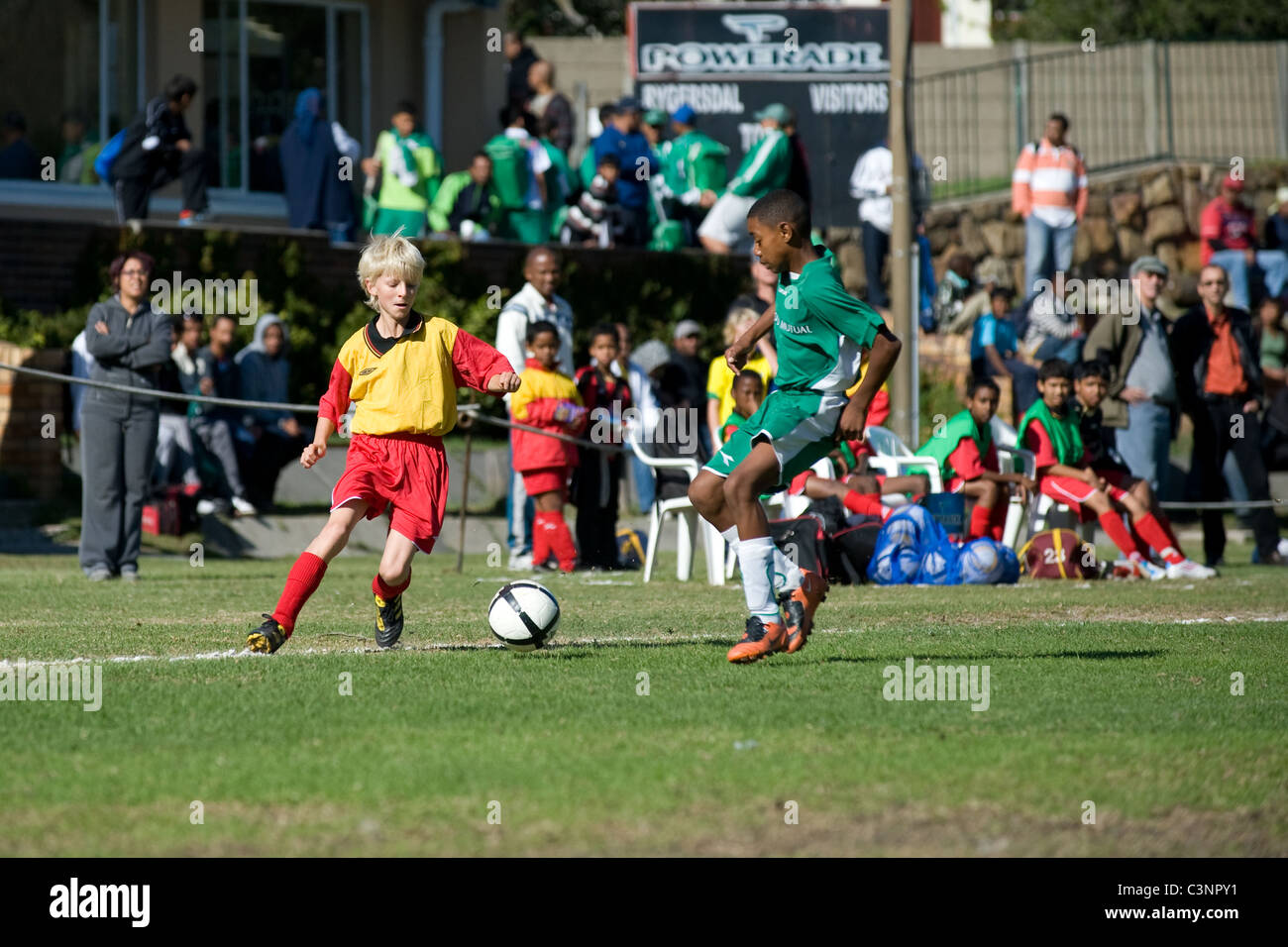 Les jeunes joueurs de football d'une équipe U13 de dribbler dans un match Cape Town Afrique du Sud Banque D'Images
