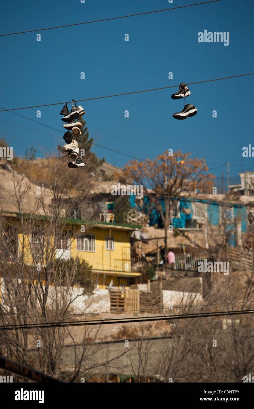 Les fils électriques pendent à chaussures marquant le territoire d'un gang dans les bidonvilles de Anarba, l'un des plus pauvres des bidonvilles de Juarez, Mexique Banque D'Images