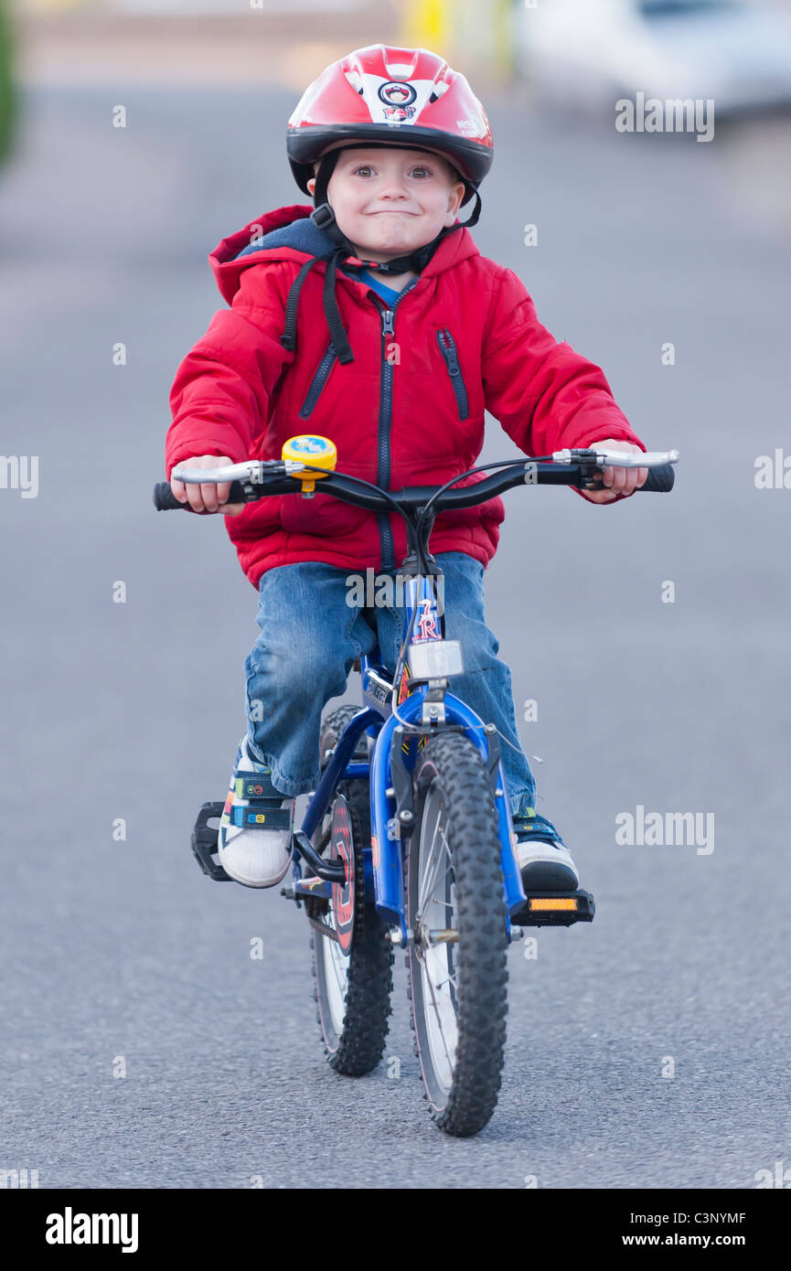 Un garçon de trois ans équitation son vélo le premier jour sans stabilisateurs dans l'Uk Banque D'Images