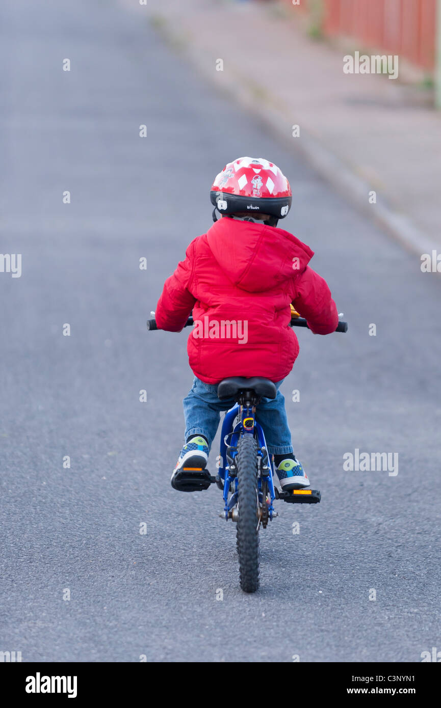 Un garçon de trois ans équitation son vélo le premier jour sans stabilisateurs dans l'Uk Banque D'Images
