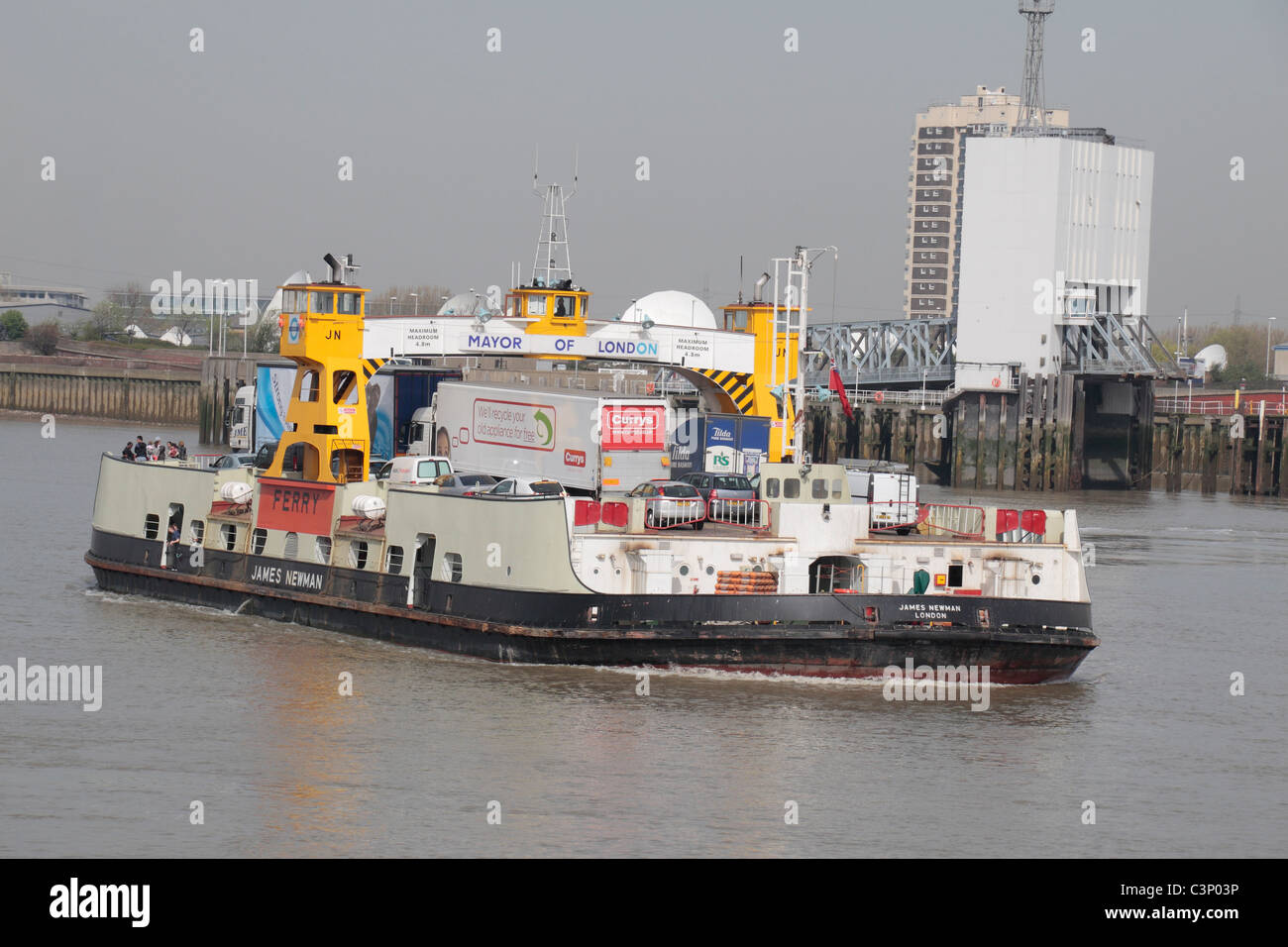 La Woolwich Ferry (le 'James Newman') traversant la Tamise, East London, UK (rive nord) derrière. Banque D'Images