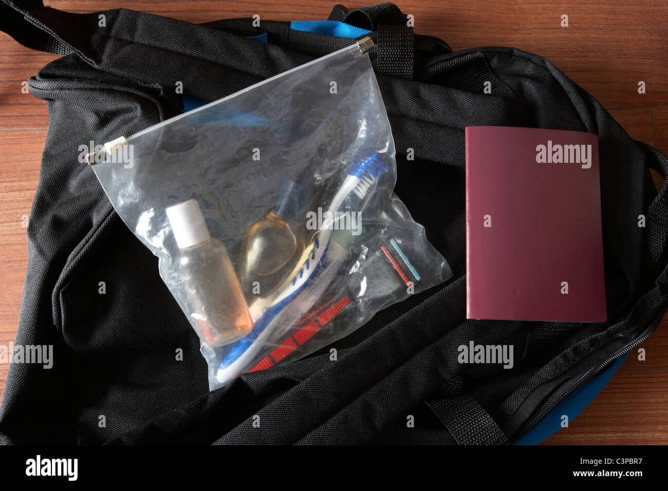 Bagages à main emballés pour voyage rapide dont passeport et d''articles de toilette à voir à travers le sac en plastique Banque D'Images