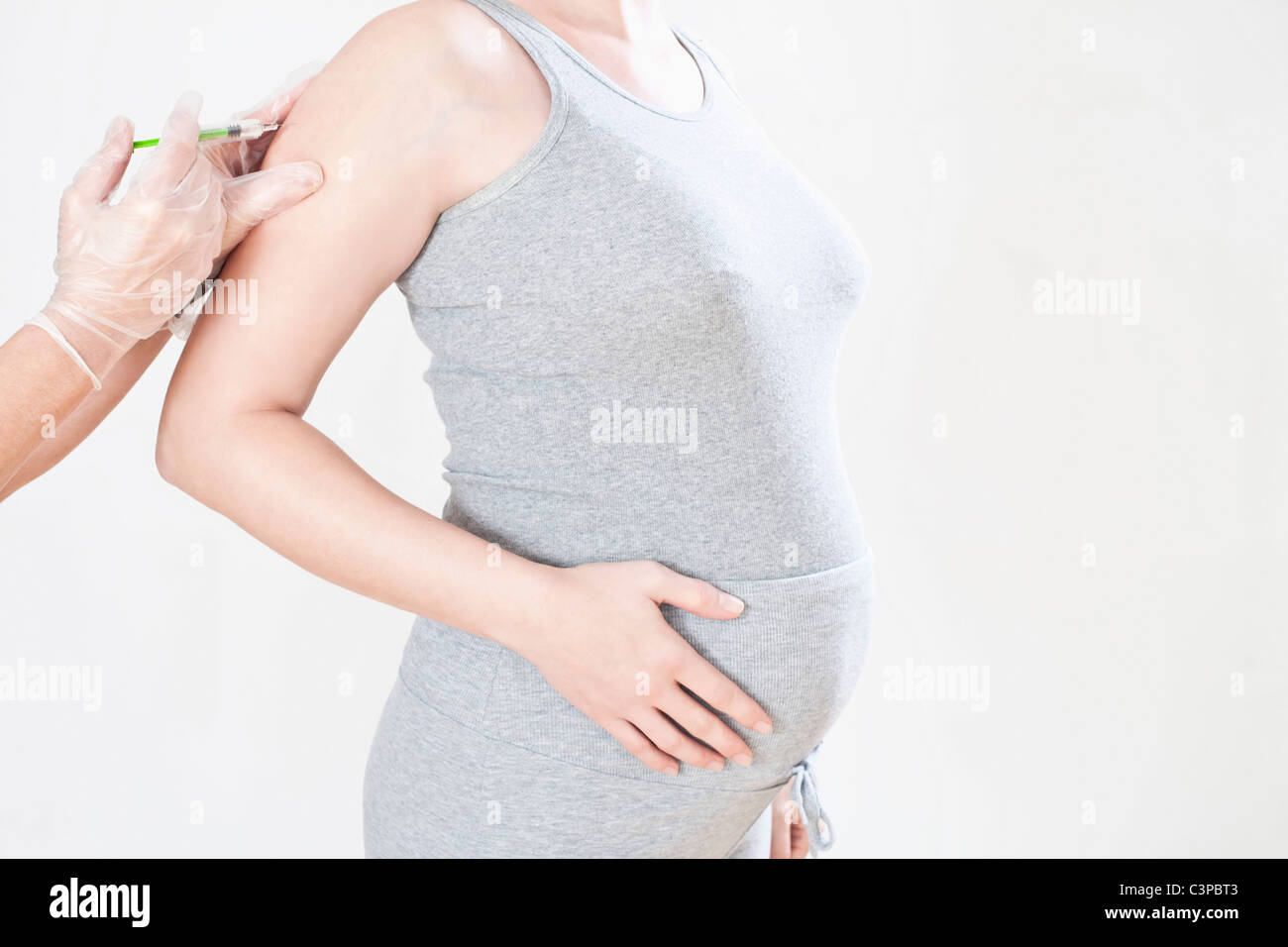 Femme enceinte obtenir une injection, mid section, side view Banque D'Images