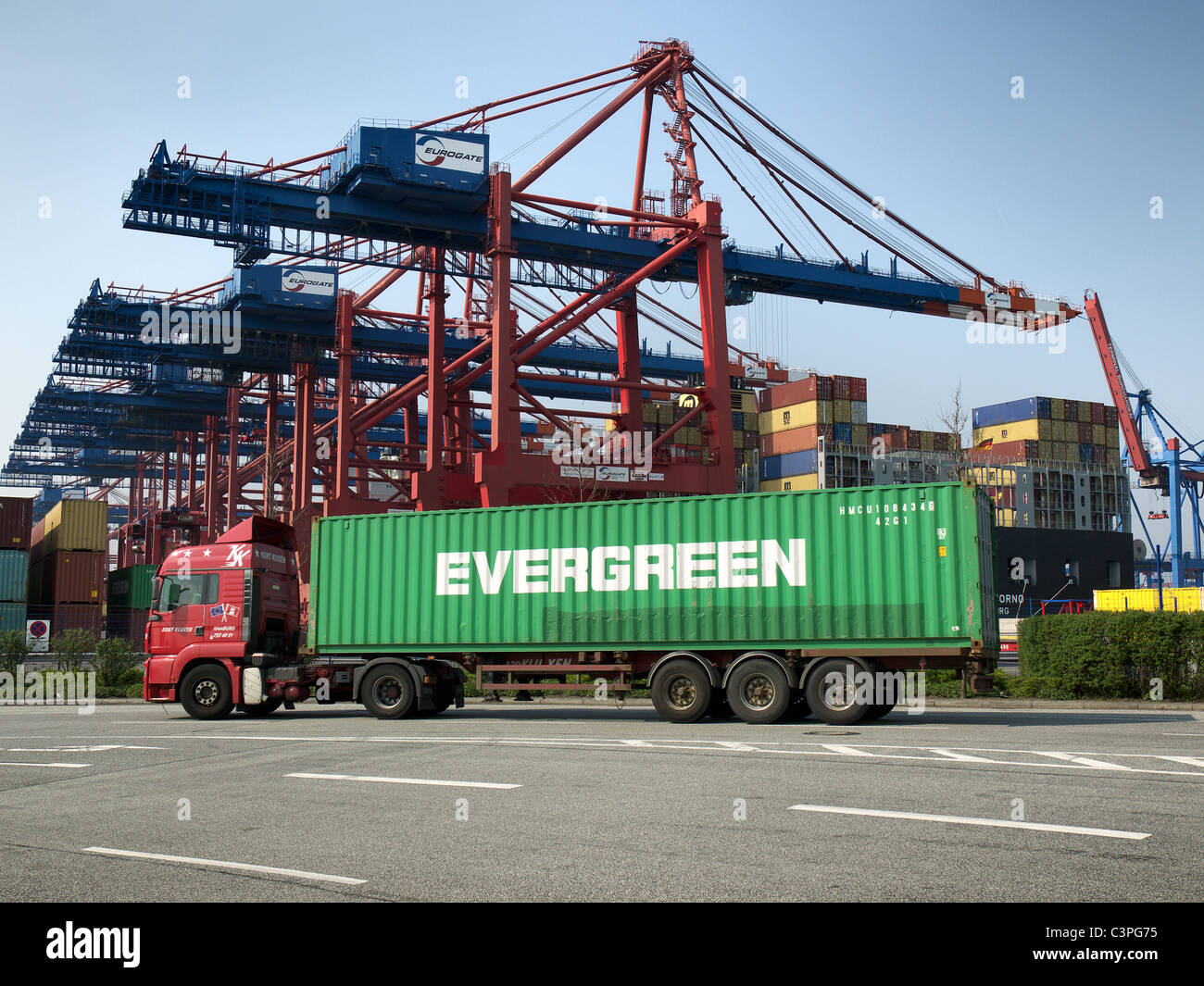 Chariot avec Evergreen 40' conteneur approchant le terminal à conteneurs Eurogate dans le port de Hambourg, Allemagne. Banque D'Images