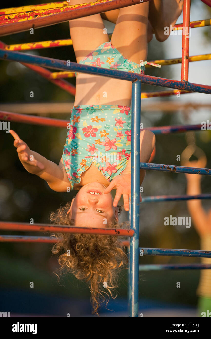 L'Allemagne, l'├╝rttemberg Baden W, Girl (4-5) tête en bas de junglegym, rire, portrait Banque D'Images