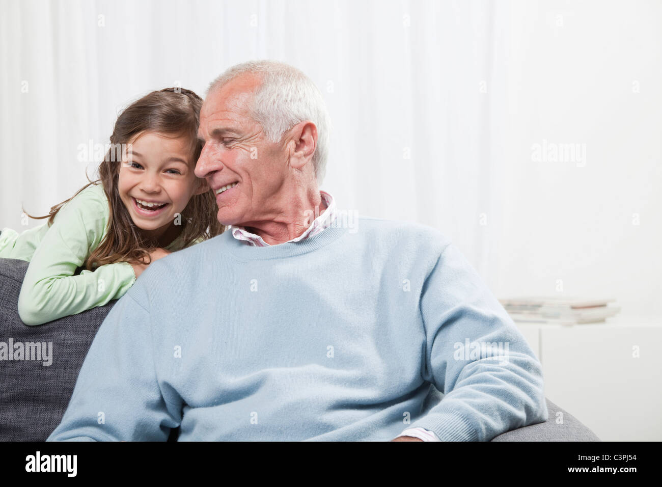 Petite-fille (6-7) et grand-père smiling Banque D'Images