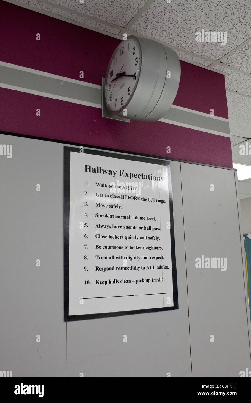 Signer avec couloir attendre règles ci-dessous réveil sur le mur de l'école intermédiaire couloir au Texas Banque D'Images