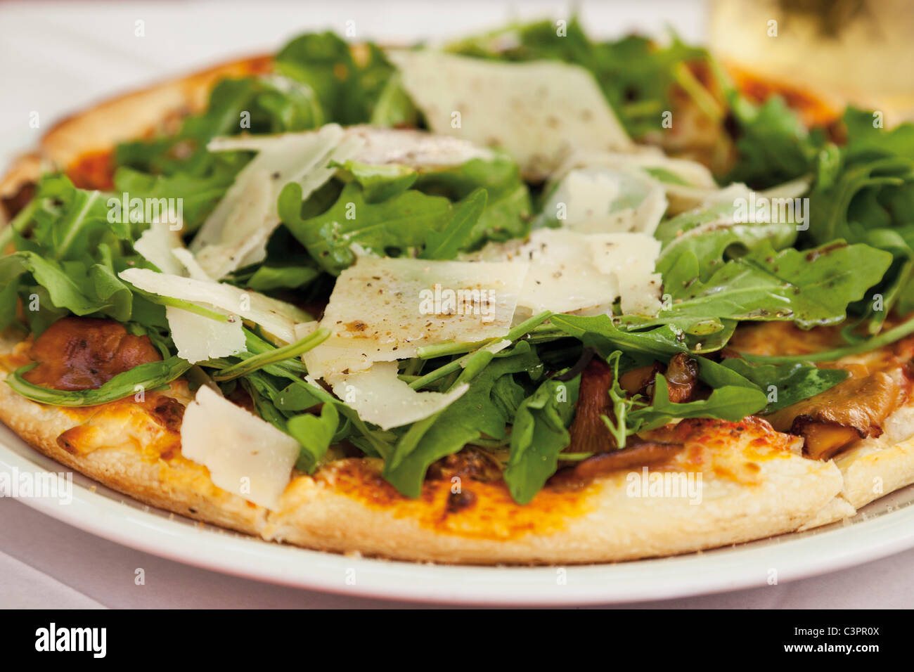 Pizza garnie de champignons et roquette Banque D'Images