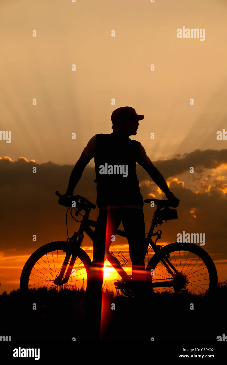 Allemagne, Bavière, Biker avec vélo au coucher du soleil Banque D'Images