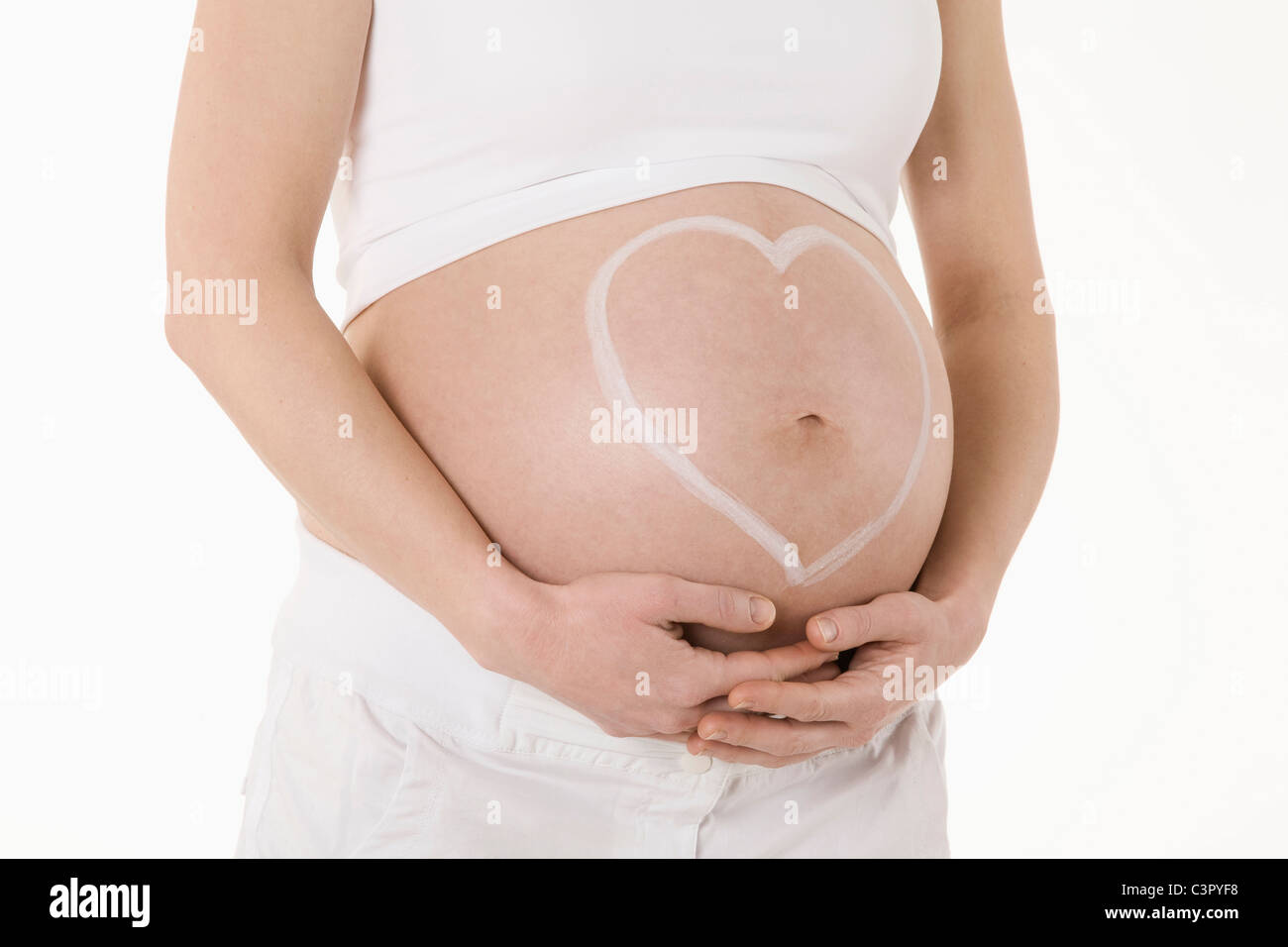 Forme de coeur dessiné sur le ventre de femme enceinte, portrait Banque D'Images