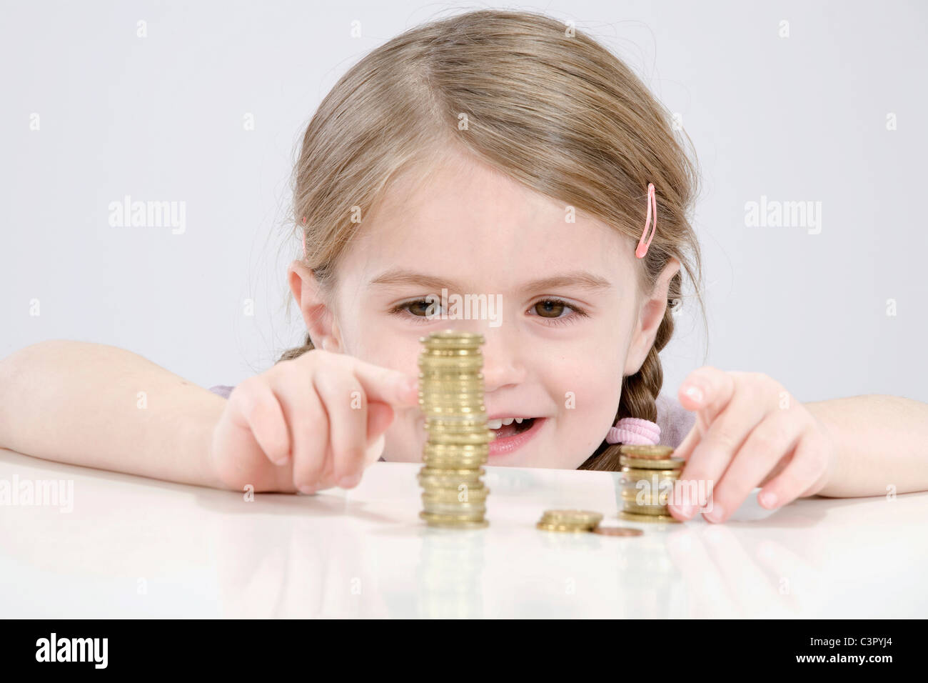 Girl (4-5) comptant pile de pièces Banque D'Images