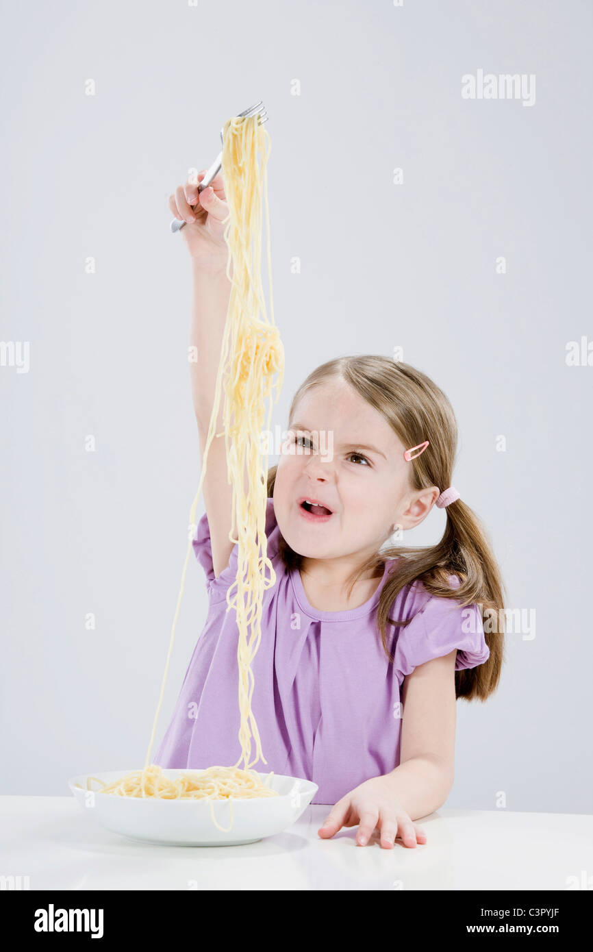Girl (4-5) en jouant avec spaghetti Banque D'Images