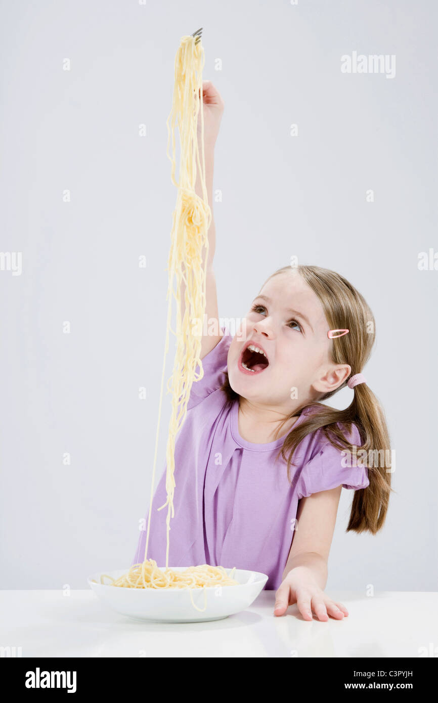 Girl (4-5) en jouant avec spaghetti Banque D'Images