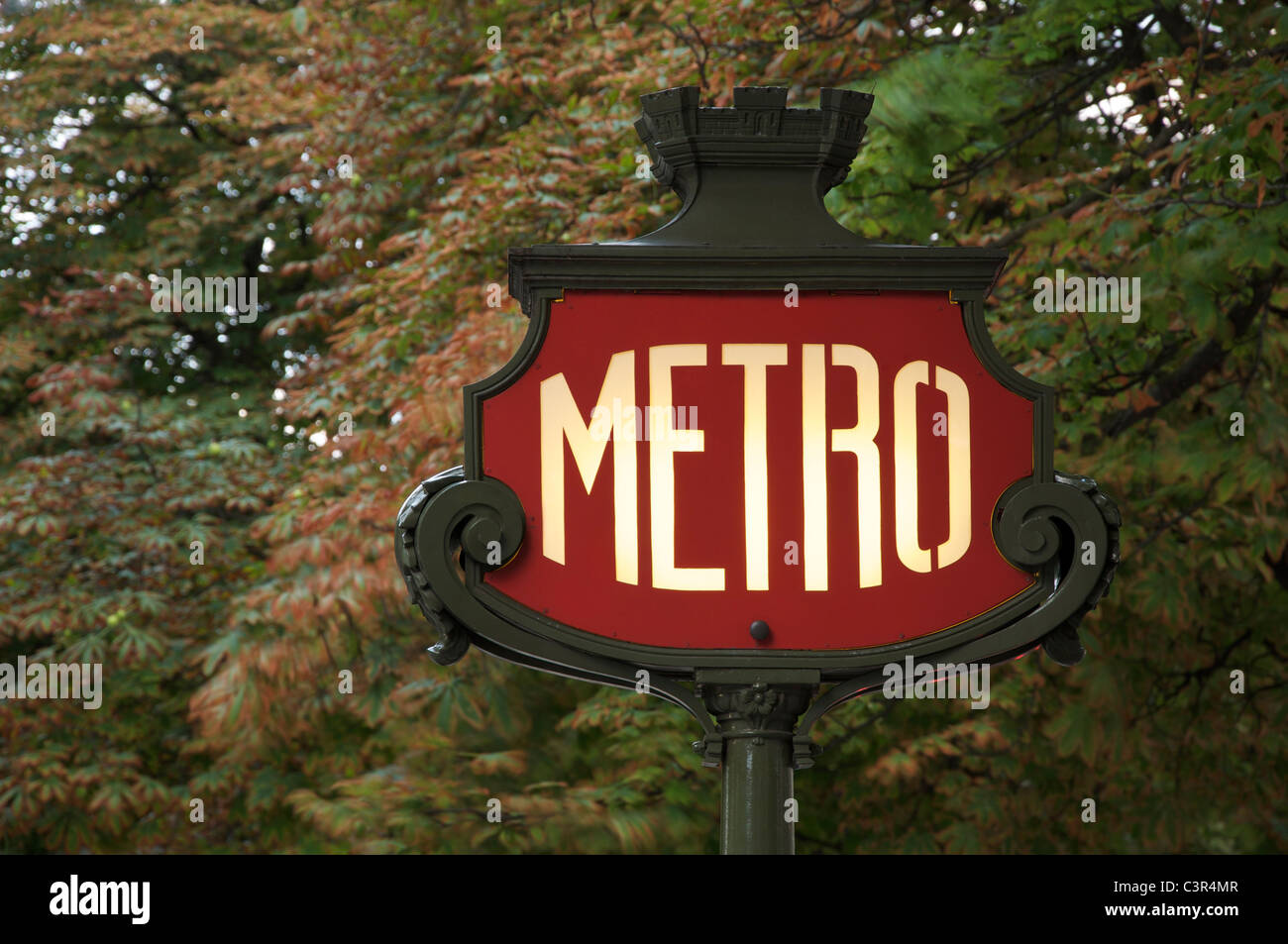 Un emblématique panneau Art Nouveau Métro parisien, sur fond de feuillage, dans l'avenue des champs Elysées. Paris, France. Banque D'Images