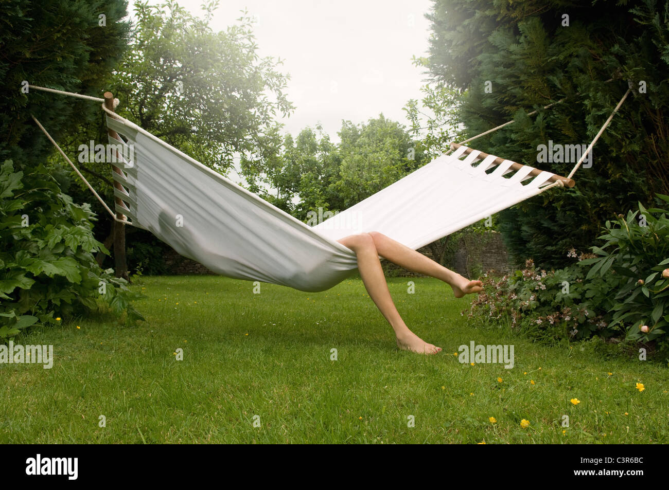 Femme relaxing in hammock Banque D'Images