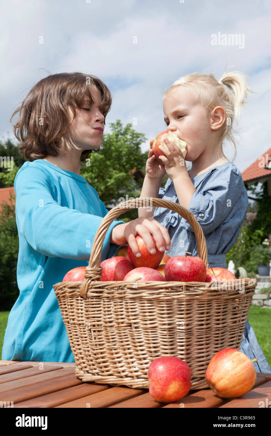 Allemagne, Munich, Girl (2-3 ans) et garçon (10-11 ans ) manger des pommes Banque D'Images