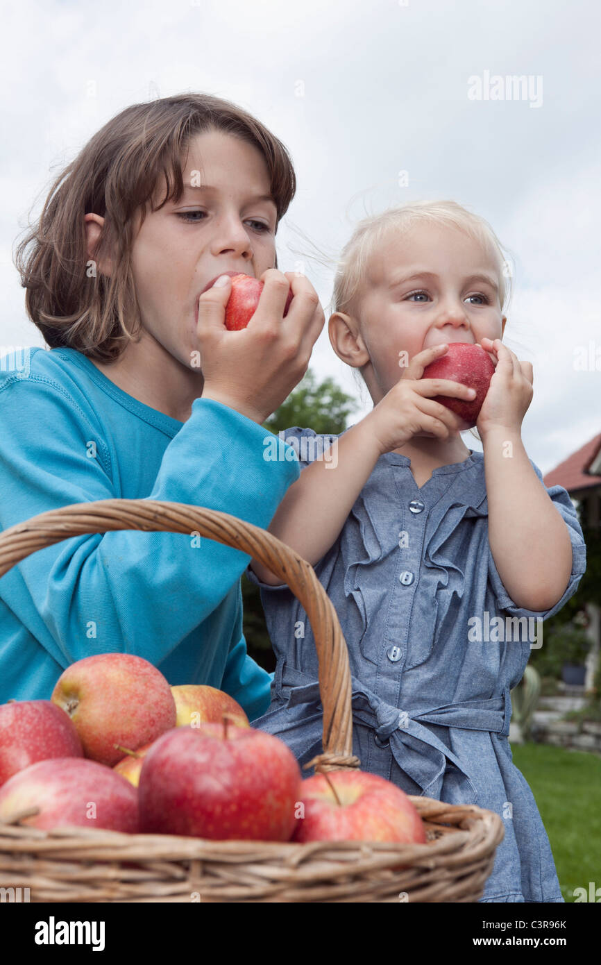 Allemagne, Munich, Girl (2-3 ans) et garçon (10-11 ans ) manger des pommes Banque D'Images