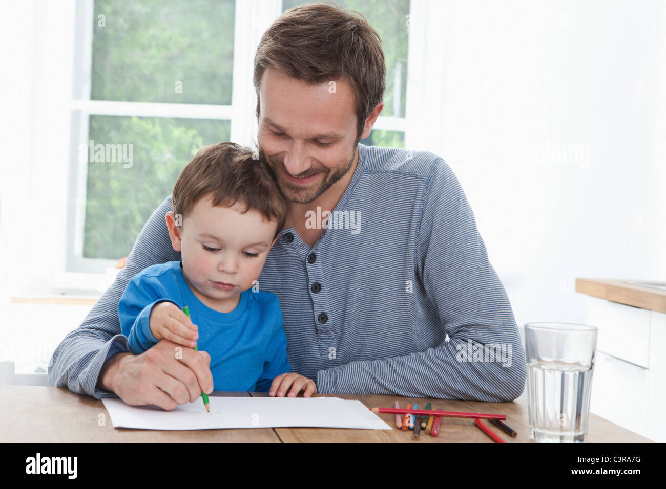Germany, Bavaria, Munich, père et fils (2-3 ans) peinture photo dans la cuisine Banque D'Images
