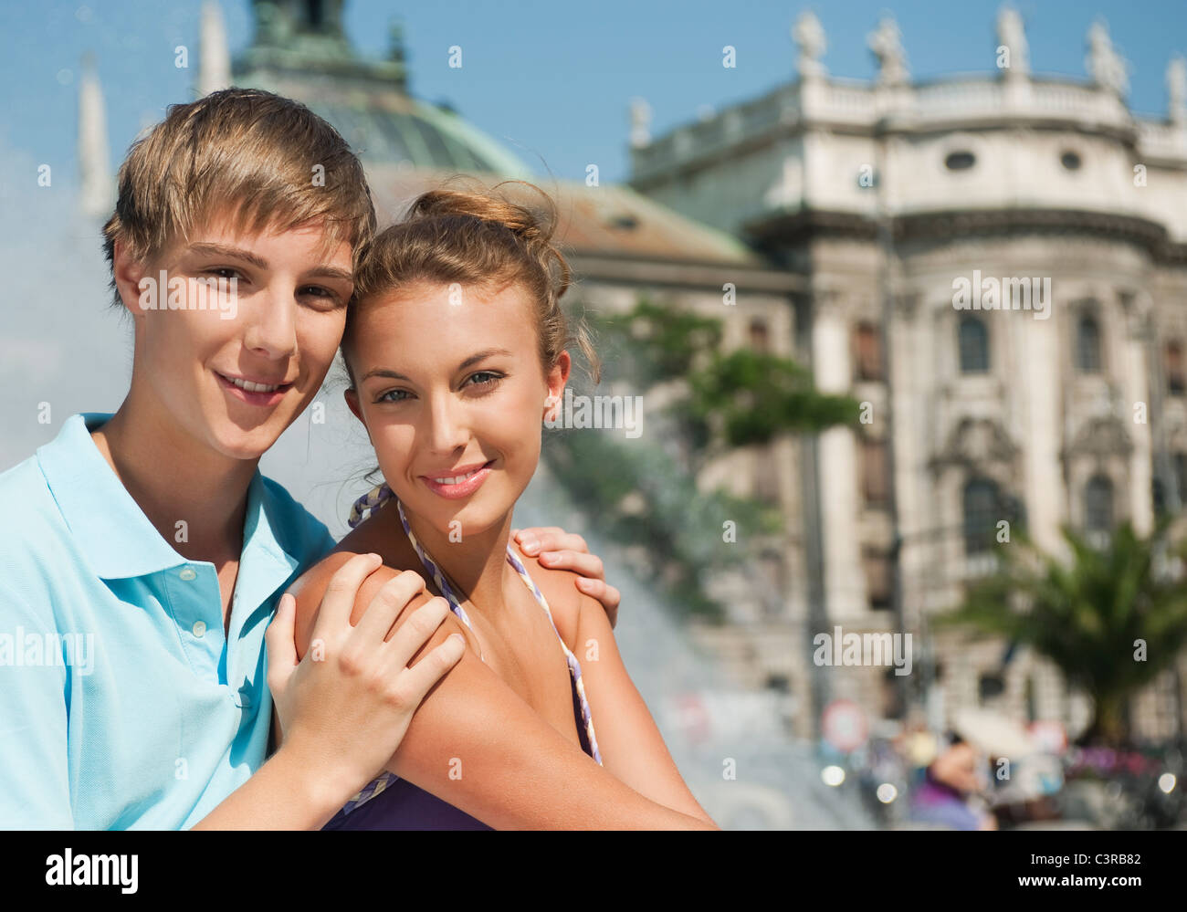 Allemagne, Munich, Karlsplatz, Young man and woman smiling, portrait Banque D'Images
