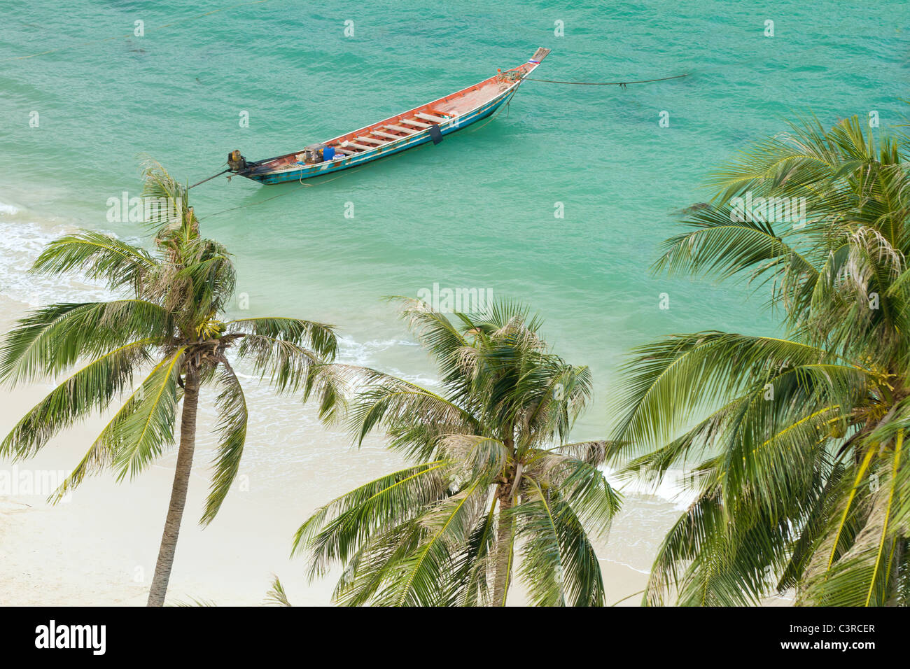 Plage tropicale avec palmiers et barque flottant sur la mer, Thaïlande Banque D'Images