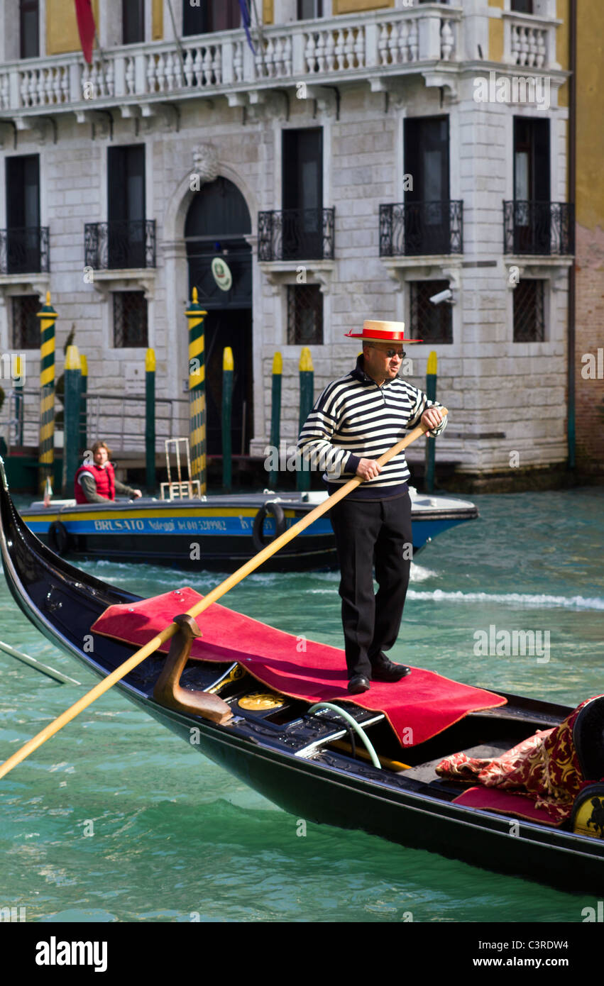 Gondolier steers sa gondole le long du grand canal Banque D'Images