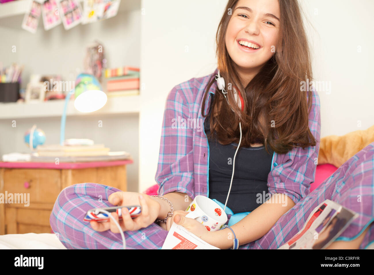 Teenage girl listening to music en pyjama Banque D'Images