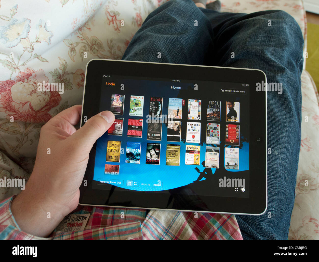 L'homme parcourt la bibliothèque numérique e-book sur Amazon Kindle app sur un écran tactile iPad tablet computer Banque D'Images