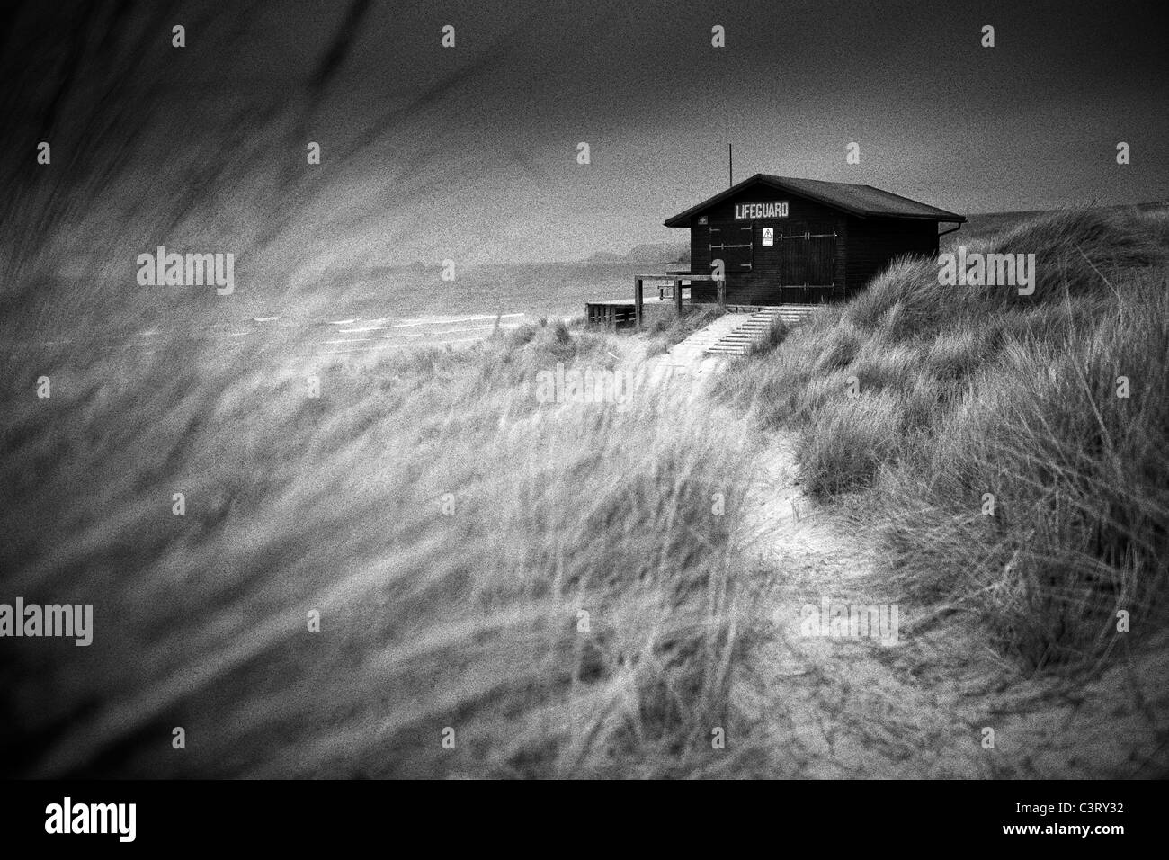 Lifeguard hut et dunes de sable sur un sombre jour, Sennen Cove, Cornwall Banque D'Images