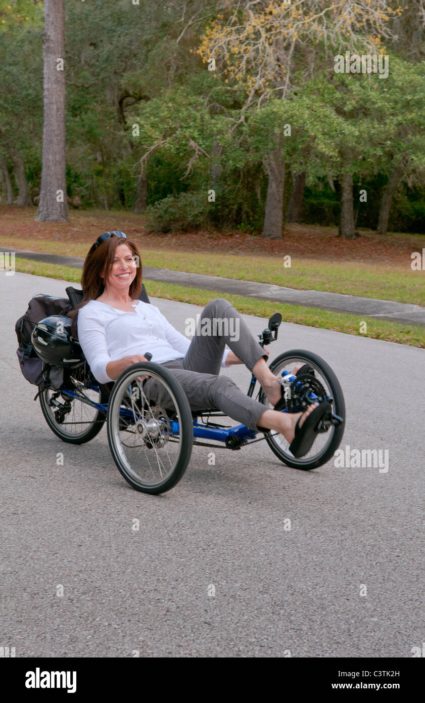 Femme ayant du plaisir de conduire le nouveau green machine appelée Terre un Trike tricycle couchés sur la route pour l'excitation autour de Banque D'Images