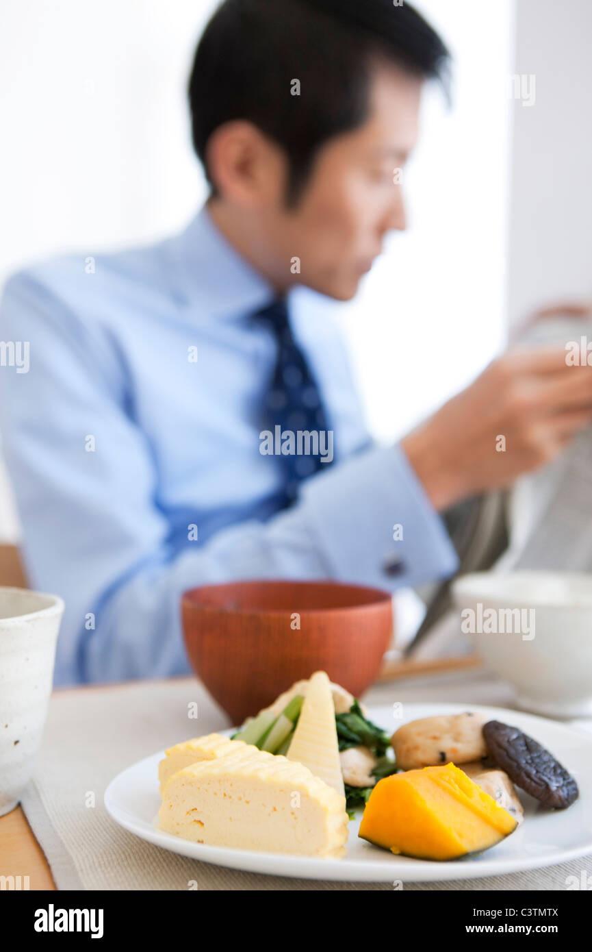 Businessman Reading Newspaper at Breakfast Table Banque D'Images
