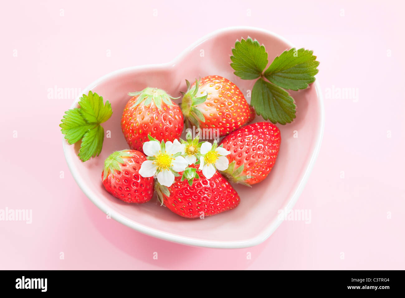 Les fraises dans un bol en forme de coeur Banque D'Images
