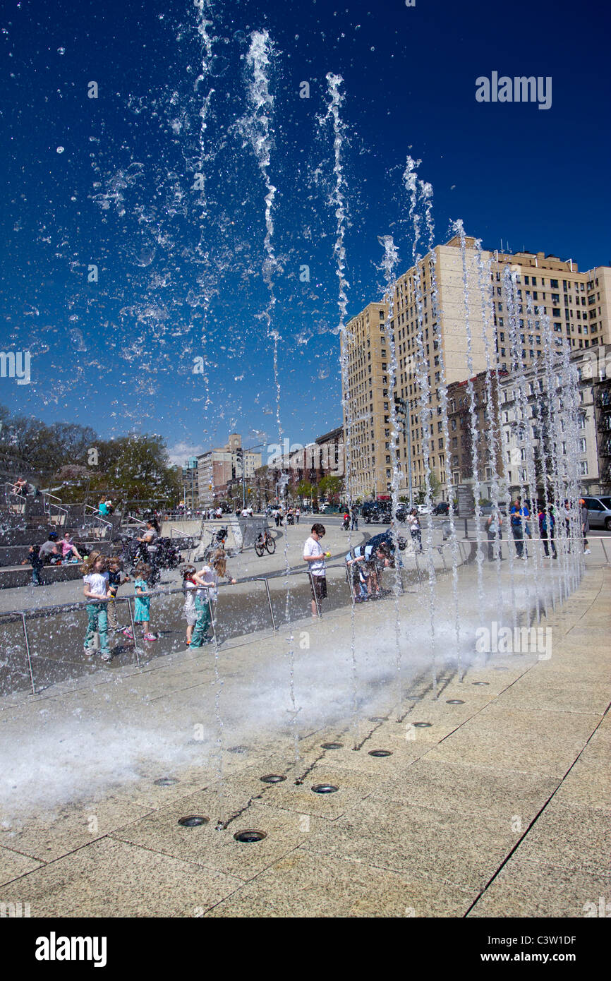 Une fontaine conçue par l'humidité de l'eau jette en l'air en face du Brooklyn Museum of Art en tant qu'enfants watch en delight Banque D'Images