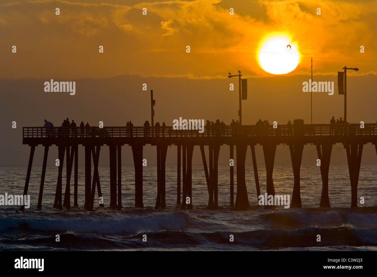 Coucher du soleil la lumière sur la jetée et les vagues de l'océan à Pismo Beach, San Luis Obispo County, Californie Côte Banque D'Images