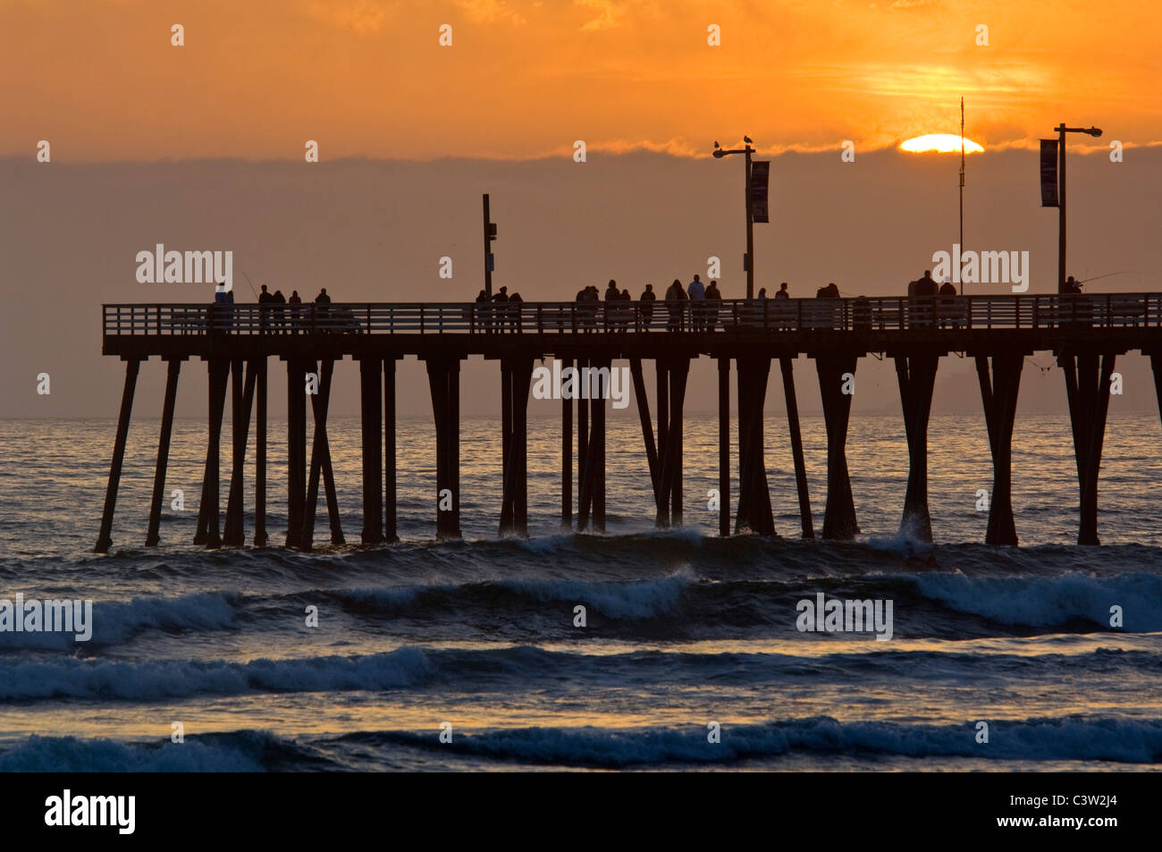 Coucher du soleil la lumière sur la jetée et les vagues de l'océan à Pismo Beach, San Luis Obispo County, Californie Côte Banque D'Images