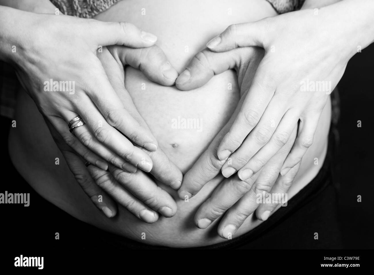 Pregnant belly et forme de coeur créé par hands Banque D'Images