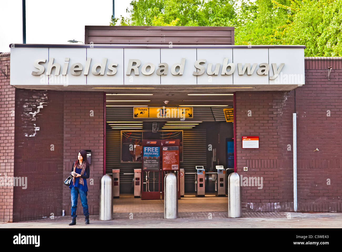 Jeune femme à l'extérieur de l'entrée de la station de métro de la route Shields, sur le circuit du chemin de fer souterrain. Banque D'Images